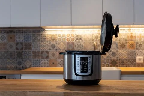 Modern multi cooker in kitchen. Open, ready to cook. Stock Photos