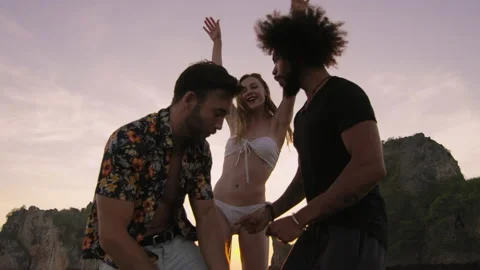 Modern multi ethnic friends dancing on deck while traveling on long tail boat to Stock Footage 201095430