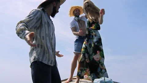 Modern multi ethnic friends dancing on deck while traveling on long tail boat to Stock Footage 201096926