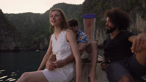 Modern multi ethnic friends hanging out at sunset, while traveling on long tail 動画素材 199477977