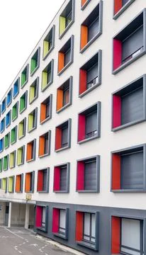 Modern multi story building facade with colorful metal panels around windows Stock Photos
