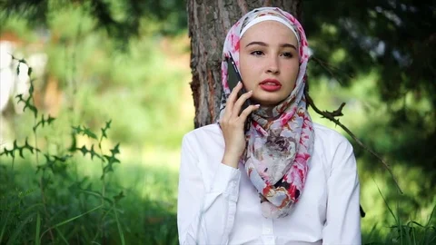 Modern Muslim girl talking on mobile outdoor Stock Footage 79354553