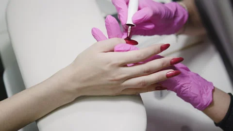 Modern Nail Art, Skilled Technician Creates Glossy Red Nails In Trendy Salon Stock Footage 324064216