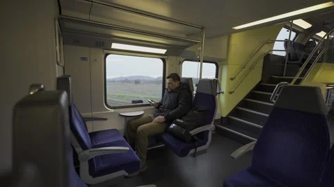 Modern nomad commuting on a deserted train in Switzerland. A lonely man in a Stock Footage 316642902