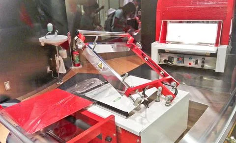 A modern noodle museum workshop machine sits behind glass Stock Photos