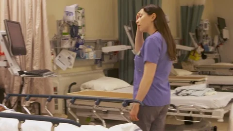 Modern nurse assesses and talks with female patient and uses computer. Video stock 77724951
