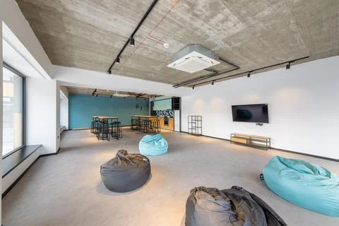 Modern Office Break Room with Bean Bag Chairs, TV, Kitchenette, and Industr.. Stock-Fotos
