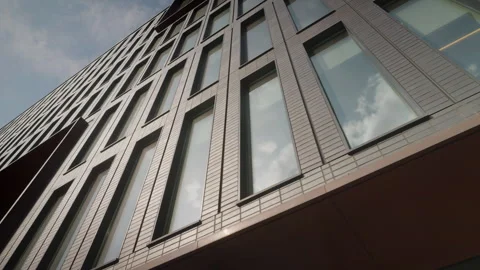 Modern office building, bottom view on clouds reflected at large glass windows Stock Footage 258780529