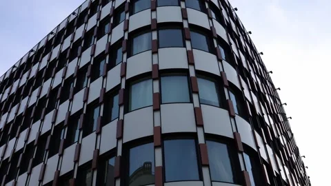 Modern office building with curved architecture, glass windows, and geometric fa Stock Footage 304885381