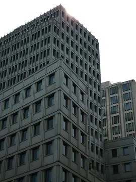 Modern office building facade with rows of windows against bright sky Stock Photos