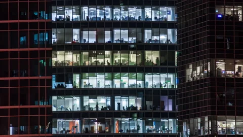 Modern office building with large windows at night, light shines in the windo Stock Footage 146615195