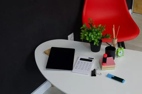 Modern office desk setup with tablet, calculator, and plant for productivity Stock Photos