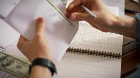 In a modern office environment a businessman carefully places cash into an e Stock Footage 336569934