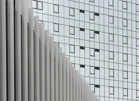 Modern office facade with geometric window grid and vertical white fins. Stock Photos