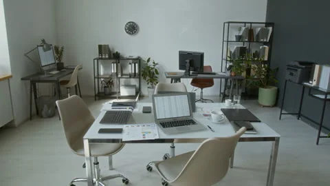 Modern Office Featuring White Table with Laptop Displaying Spreadsheet Stock Footage 312047803