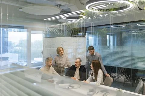 A modern office interior, featuring a blurred view of workers at desks, thr.. Stock Photos