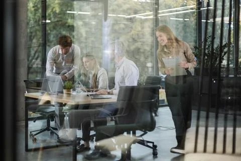 A modern office interior, featuring a blurred view of workers at desks, thr.. Stock Photos