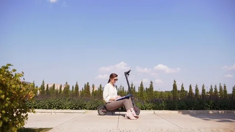 Modern office worker in a cityscape. Attractive slim girl is sitting on an Stock Footage 116557975
