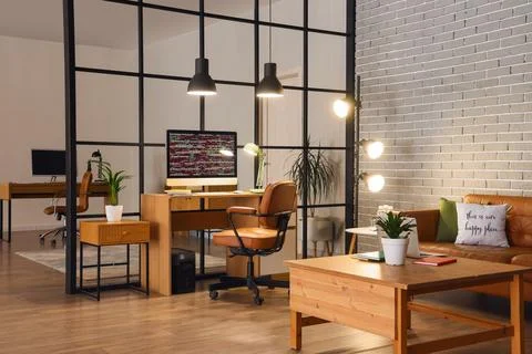 Modern office workspace with computer and cozy seating area Stock-Fotos