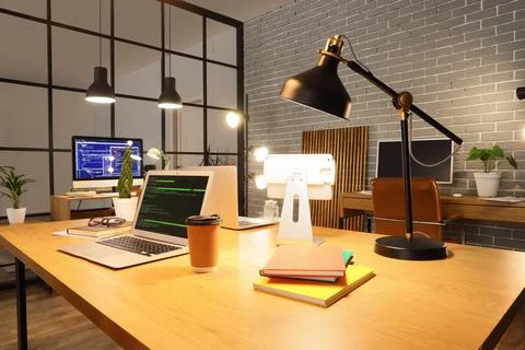 Modern office workspace with laptops and coding screens Stock Photos