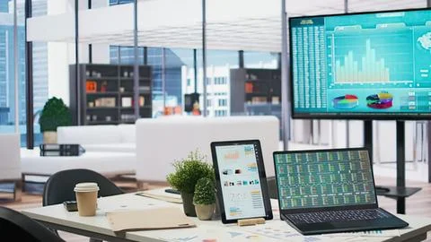 Modern office workspace with tech devices and city view Stock Photos