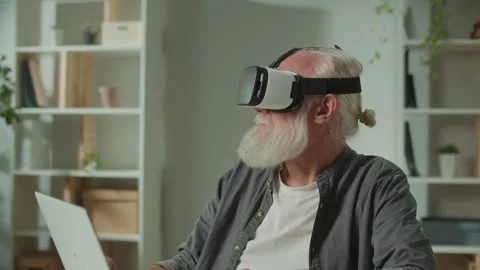 A Modern Old Man in VR Glasses Examines Everything Around. Stock Footage 249712509