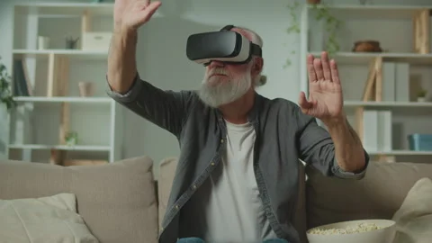 A Modern Old Man in VR Glasses Examines and Touches Everything Around. Video stock 250304741