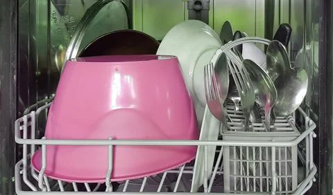Modern open dishwasher with a set of clean washed dishes, close-up Stock Photos