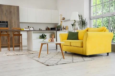 Modern open plan kitchen and living room interior with yellow sofa and large  Stock Photos