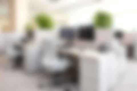 Modern open-plan office workspace with desks, chairs, computers, and natura.. Stock Photos