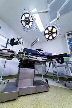 Modern operating room with surgical table and led lamps Stock Photos