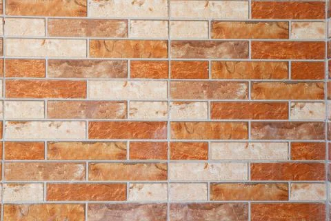 Modern orange and beige split-face decorative brick tile wall texture Stock Photos