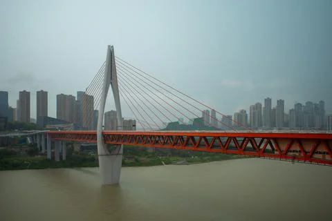 Modern orange cable-stayed bridge spans wide river Photos