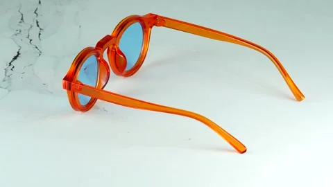 Modern orange transparent glasses rotating 360 degrees on a white background 스톡 동영상 334553970