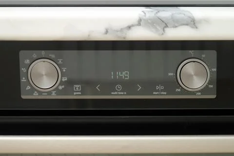Modern oven control panel with digital timer and metal knobs under marble kit Stock Photos