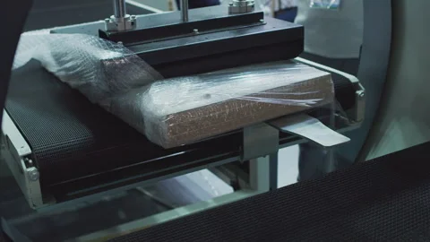 Modern packing machine packs the finished product in a plastic film. close-up Stock Footage 257010298