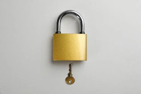 Modern padlock with key on light background, flat lay Foto stock