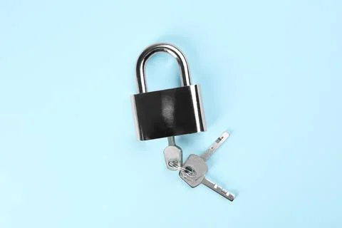 Modern padlock with keys on light blue background, top view Stockfoto's