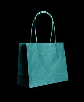 Modern paper shopping bag in transformative teal tone placed against black Stock Photos
