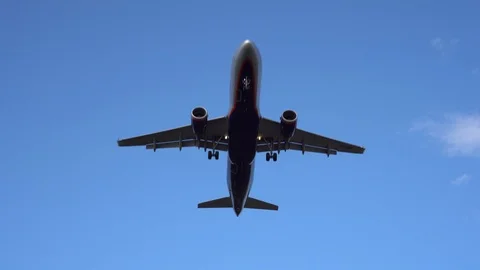 Modern passenger plane flies overhead, exactly in the center of the frame. 4K Stock Footage 117376658