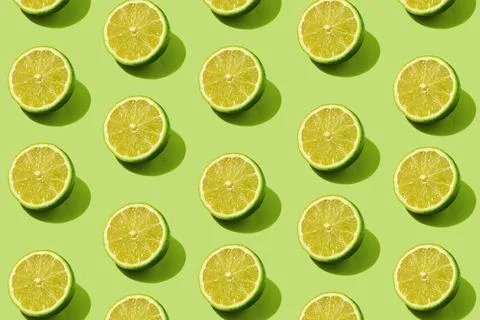 Modern pattern with lime slices on a green background illuminated by bright s Stock Photos