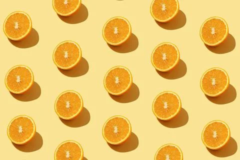 Modern pattern with orange slices on yellow background illuminated by bright  Stock Photos