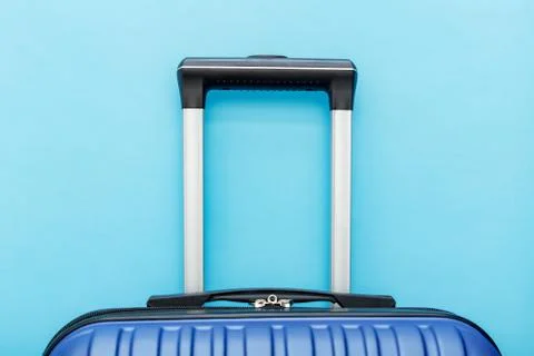 Modern Phantom Blue classic blue suitcase on blue background close up with co Stock Photos