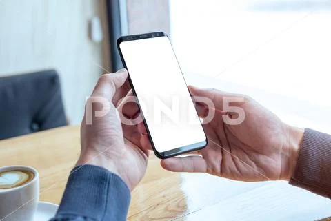 Modern phone mockup in man hand. Coffee shop interior Modello PSD