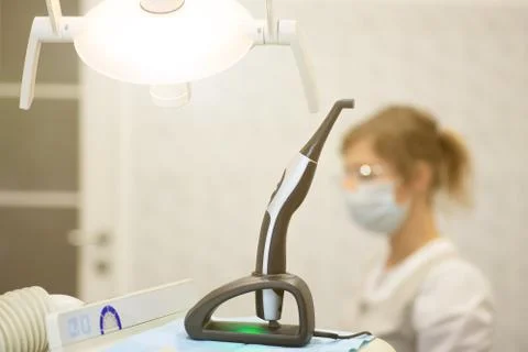 A modern photopolymerization lamp for light fillings in the dental office, on Stock Photos