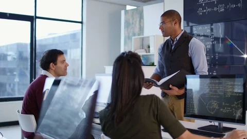Modern physics teacher guiding students during lecture Stock Footage 106673930