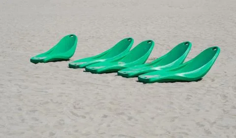 Modern plastic beach sunbeds on a sandy beach Stock Photos