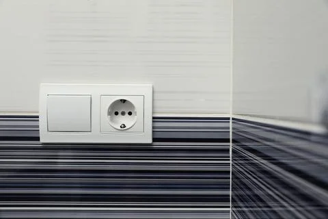 Modern plastic light switch and socket on color wall indoors Stock Photos