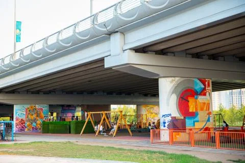 Modern playground built under large concrete overpass. Urban sport area Stock Photos