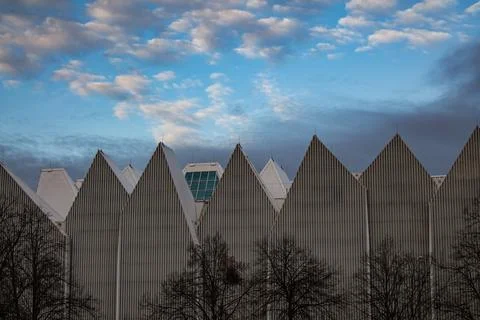 Modern pointed rooftops under a cloudy sky Stock Photos